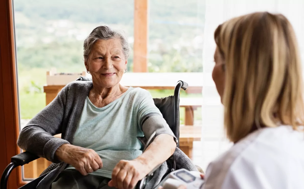 Resident speaking with carer in bright room